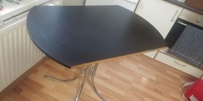 Menší stůl z černého lamina s kovovymi nohami