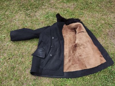 Starý černý zimni kabát s kožešinovou podšívkou