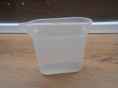 Plastová nádobka k žehličce na vodu.