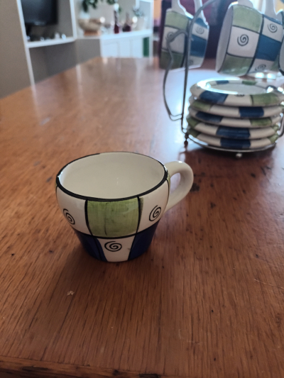 Sada malých hrnečku s talířky na stojánku