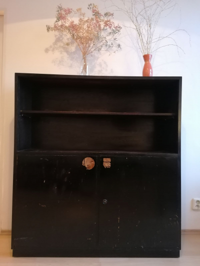 Černá dřevěná skříň s policemi
