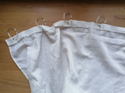 2 bílé sprchové závěsy